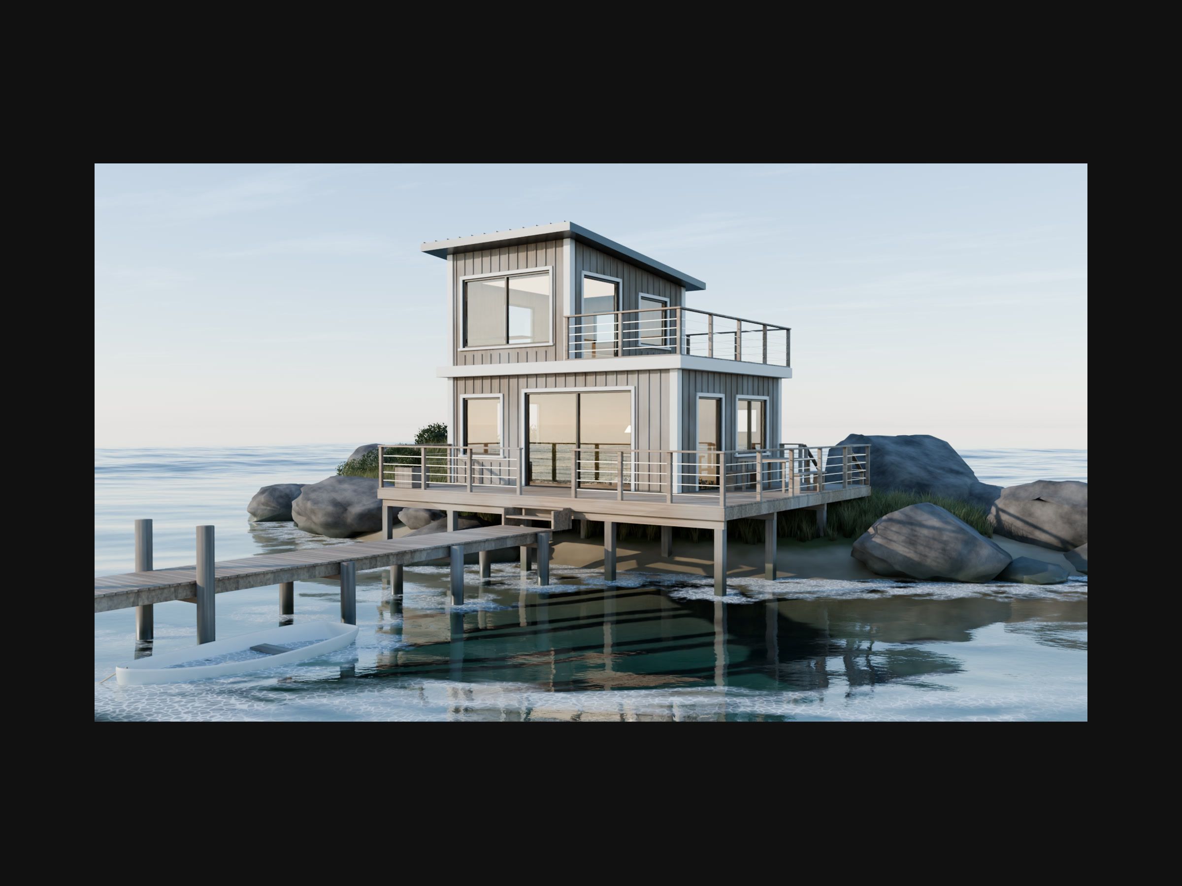 A two-storey wooden house on stilts beside rocks and a jetty, over calm water.