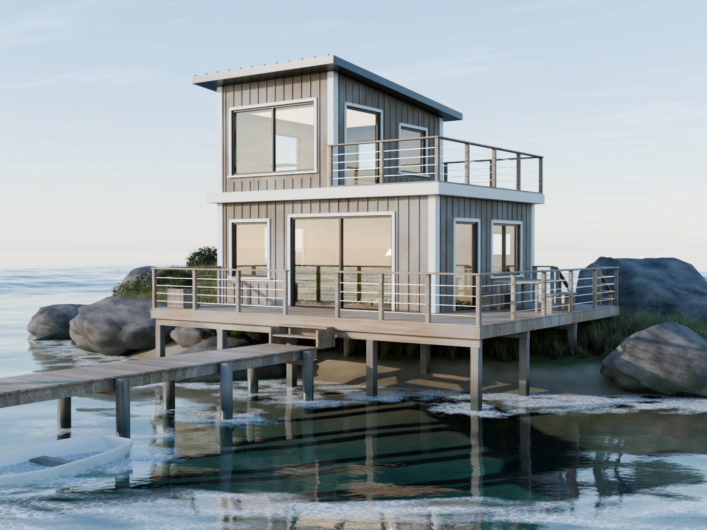 A two-storey wooden house on stilts beside rocks and a jetty, over calm water.